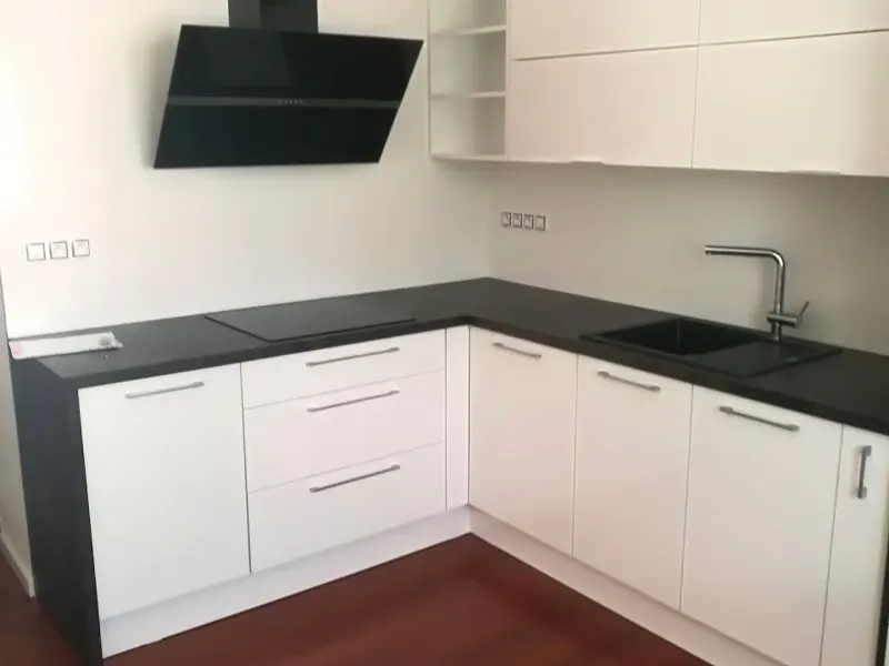 Bílá kuchyňská linka na míru s tmavou pracovní deskou po rekonstrukci