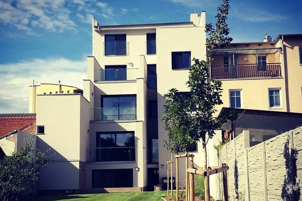 Stejný dům po dokončení rekonstrukce, nová fasáda, balkony a zahrada